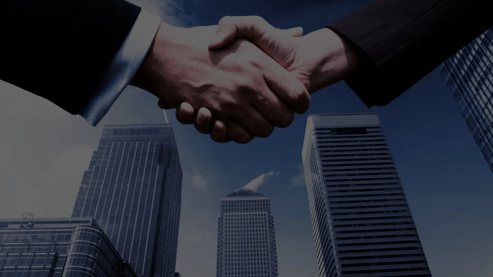 Handshake in front of office towers